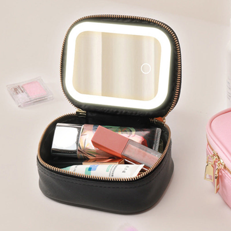 Black makeup case with a mirror and cosmetics on a light background
